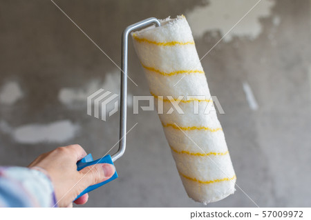 Painter hand with a paint roller 57009972