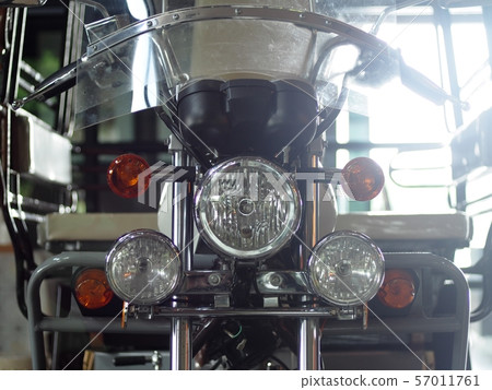 old retro vintage motorcycle front with head and turn signal lamp closeup indoor crop closeup at the headlamp old retro vintage motorcycle front with head and turn signal lamp closeup indoor crop closeup at the headlamp 57011761