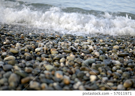Strip of wet pebbles on the seashore. 57011971