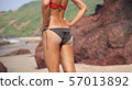 Slender young woman in dressed in black bikini 57013892