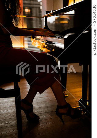Elegant woman playing on piano, dark photo 57014530