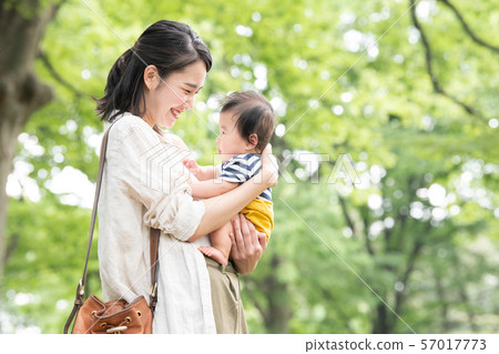 抱著嬰孩育兒育兒家庭公園新綠色的年輕母親 57017773