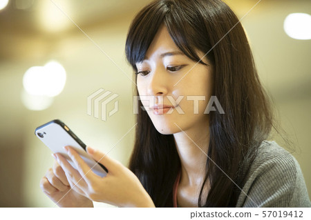 年輕的女人，溫暖的燈光，辦公室 57019412