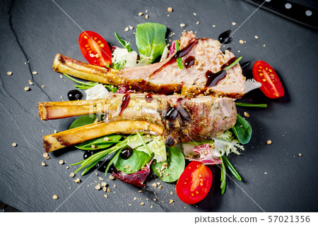 Grilled rack of lamb on slate plate Grilled rack of lamb on slate plate 57021356