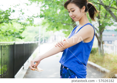 女人在手臂上塗防曬霜 女人在手臂上塗防曬霜 57026182