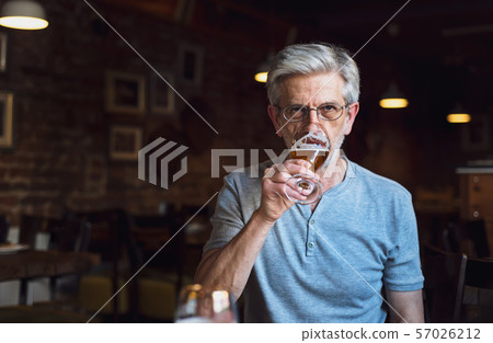 Senior man having a beer in the bar Senior man having a beer in the bar 57026212