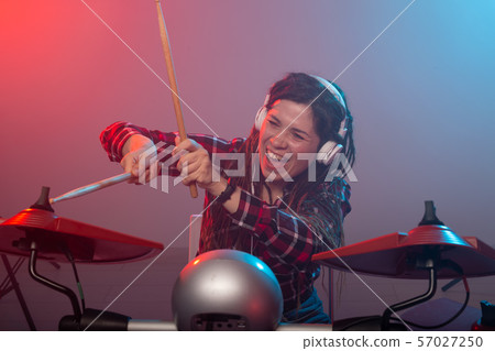 Music, drum and hobby concept - young woman playing the electronic drum set at the club Music, drum and hobby concept - young woman playing the electronic drum set at the club 57027250