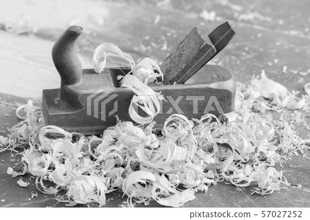 Old wooden hand plane for woodworking with wood shavings. Black and white. 57027252