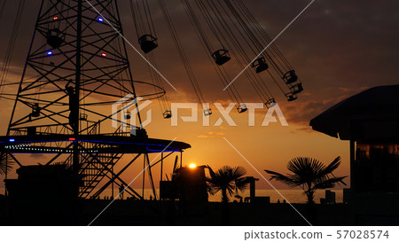 Swinging carousel roundabout chain ride at sunset Swinging carousel roundabout chain ride at sunset 57028574