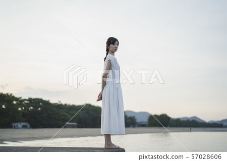 Woman in the sea at sunset 57028606