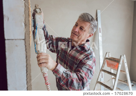 Plasterer smoothing interior wall with machine 57028670