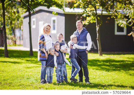 Happy Family Outdoors. Happy Caucasian family standing outside their house and hugging. Family with 57029664