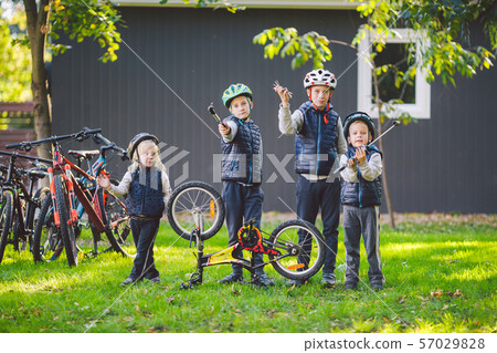 Children mechanics, bicycle repair. Happy kids fixing bike together outdoors in sunny day. Bicycle Children mechanics, bicycle repair. Happy kids fixing bike together outdoors in sunny day. Bicycle 57029828