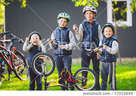 Children mechanics, bicycle repair. Happy kids fixing bike together outdoors in sunny day. Bicycle 57029848