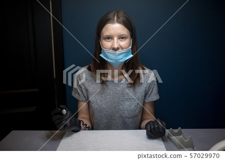 master with permanent machine. Portrait of a professional tattoo master woman. Place of work tattoo 57029970