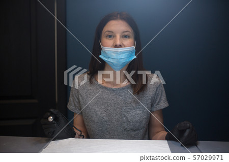 master with permanent machine. Portrait of a professional tattoo master woman. Place of work tattoo 57029971