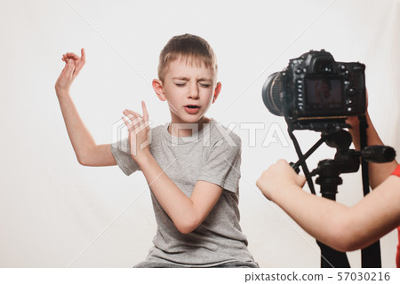 Boy enthusiastically sings in front of the camera. 57030216
