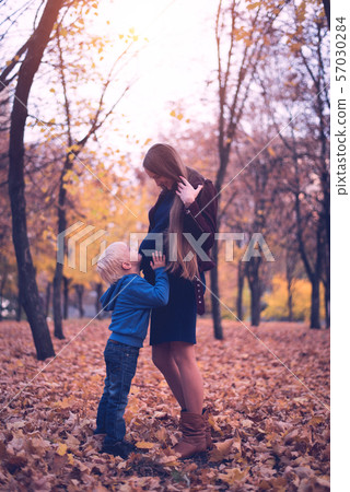 Little blond boy hugs his pregnant mom's belly. 57030284