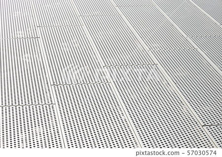 Diagonal view of metall grilles and round holes in metal surface, perforated panels 57030574