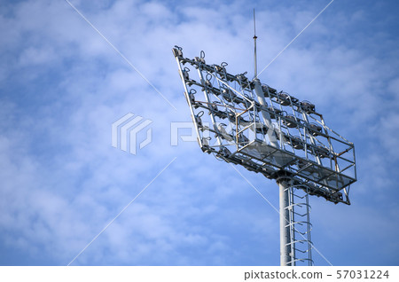 Sport stadium spotlight with blue sky background. 57031224