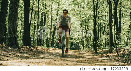 Men is riding on bicycle. 57033339