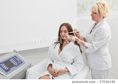 beautiful brunette young woman having relaxing procedure on her face 57036140