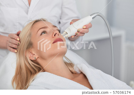 young fair-haired woman cleansing and peeling her face young fair-haired woman cleansing and peeling her face 57036174