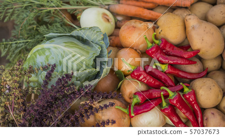 Set of seasonal vegetables - potatoes, onions and cabbage and hot red pepper in the foreground 57037673