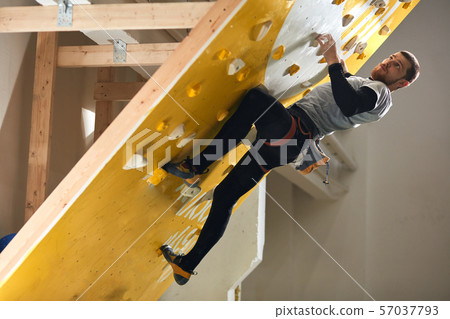 Athletic male boulderer with physical disability climbing at steep rock wall Athletic male boulderer with physical disability climbing at steep rock wall 57037793