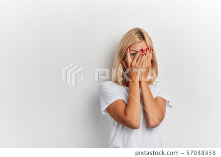 shy girl hiding behind her palms 57038338