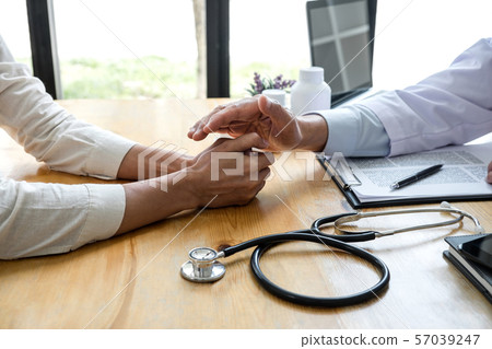 Professor doctor touching patient hand for 57039247