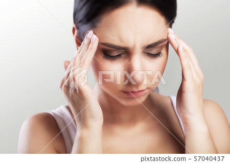 Pain. Portrait of a beautiful young brunette with a bare shoulder, feels great headache, health 57040437