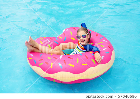 Child in swimming pool on donut float Child in swimming pool on donut float 57040680