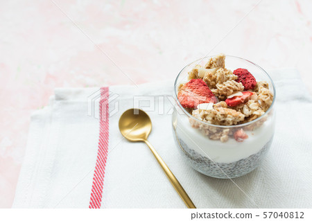 Chia pudding with almond milk, yogurt, and dried strawberries and almonds in a glass Chia pudding with almond milk, yogurt, and dried strawberries and almonds in a glass 57040812