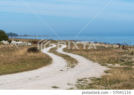 Winding gravel road along the coast 57041110