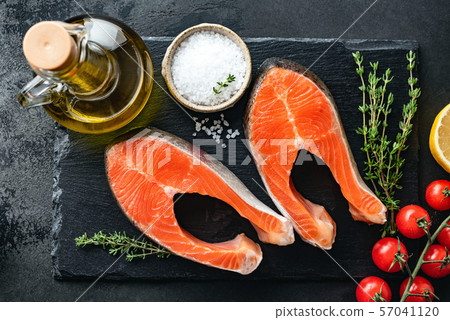 Salmon steaks and spices for cooking on black slate Salmon steaks and spices for cooking on black slate 57041120