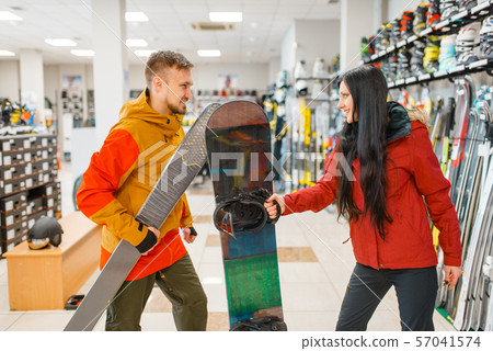 Couple buying downhill ski and snowboard, shopping Couple buying downhill ski and snowboard, shopping 57041574