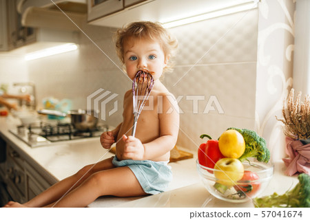 Kid tastes melted chocolate, pastry preparation Kid tastes melted chocolate, pastry preparation 57041674