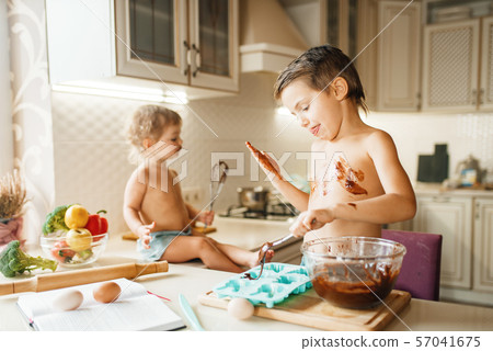 Little kids prepares pastry with melted chocolate 57041675
