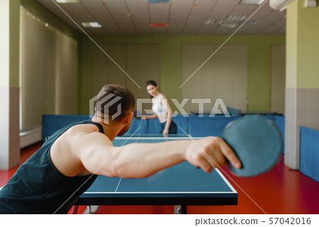 Man and woman playing ping pong, focus on racket Man and woman playing ping pong, focus on racket 57042016