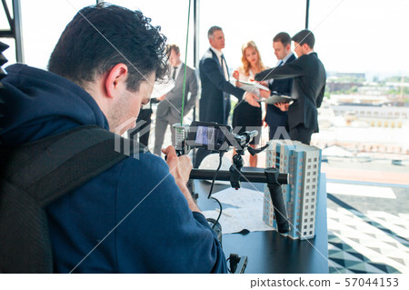 Videographer filming business meeting Videographer filming business meeting 57044153