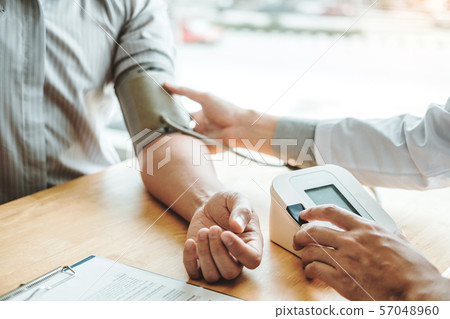 Doctor Measuring arterial blood pressure man Doctor Measuring arterial blood pressure man 57048960