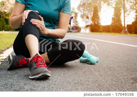fitness woman runner feels pain on knee. Outdoor exercise activities concept 57049198