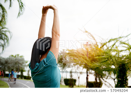 fitness woman runner stretching arm before run. Outdoor exercise activities concept 57049204