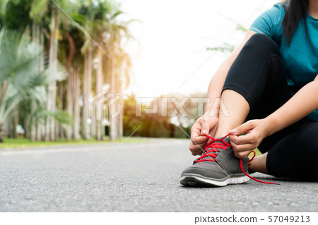 sport woman tying shoelace before running, outdoor activities 57049213