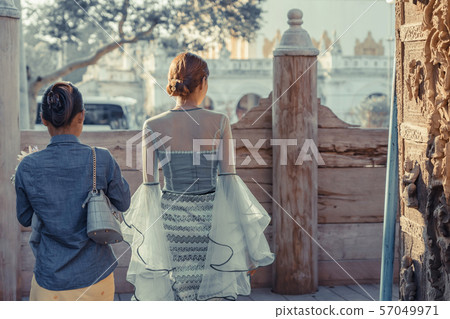 Female tourist take a photo at Shwe Nan Daw Kyaung (Golden Palace Monastery) in Mandalay, Myanmar. 57049971