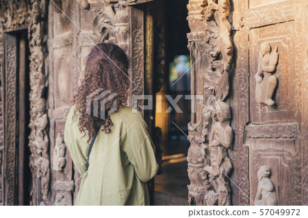 Female tourist take a photo at Shwe Nan Daw Kyaung (Golden Palace Monastery) in Mandalay, Myanmar. 57049972