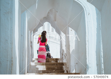 Female tourists walking and photographing at Mya Thein Tan Pagoda in Mingun, Myanmar. Female tourists walking and photographing at Mya Thein Tan Pagoda in Mingun, Myanmar. 57049974