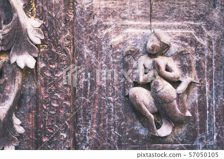 Archaeological, Close Up of carved art figures on old wood carvings on the wall temple at Shwe Nan Daw Kyaung (Golden Palace Monastery) in Mandalay, Myanmar Archaeological, Close Up of carved art figures on old wood carvings on the wall temple at Shwe Nan Daw Kyaung (Golden Palace Monastery) in Mandalay, Myanmar 57050105
