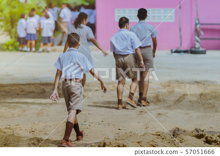Back view of the teacher and the students walking go to study at the classroom in the building Back view of the teacher and the students walking go to study at the classroom in the building 57051666